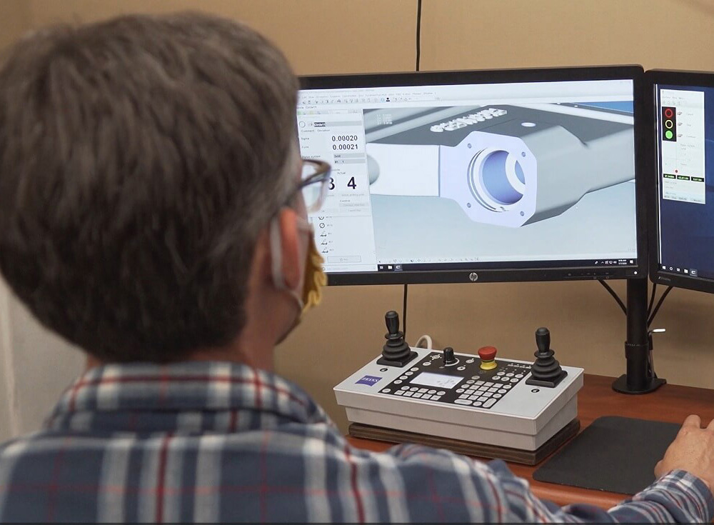 Experienced technician looking at a screen with CAD model used for inspection purposes
